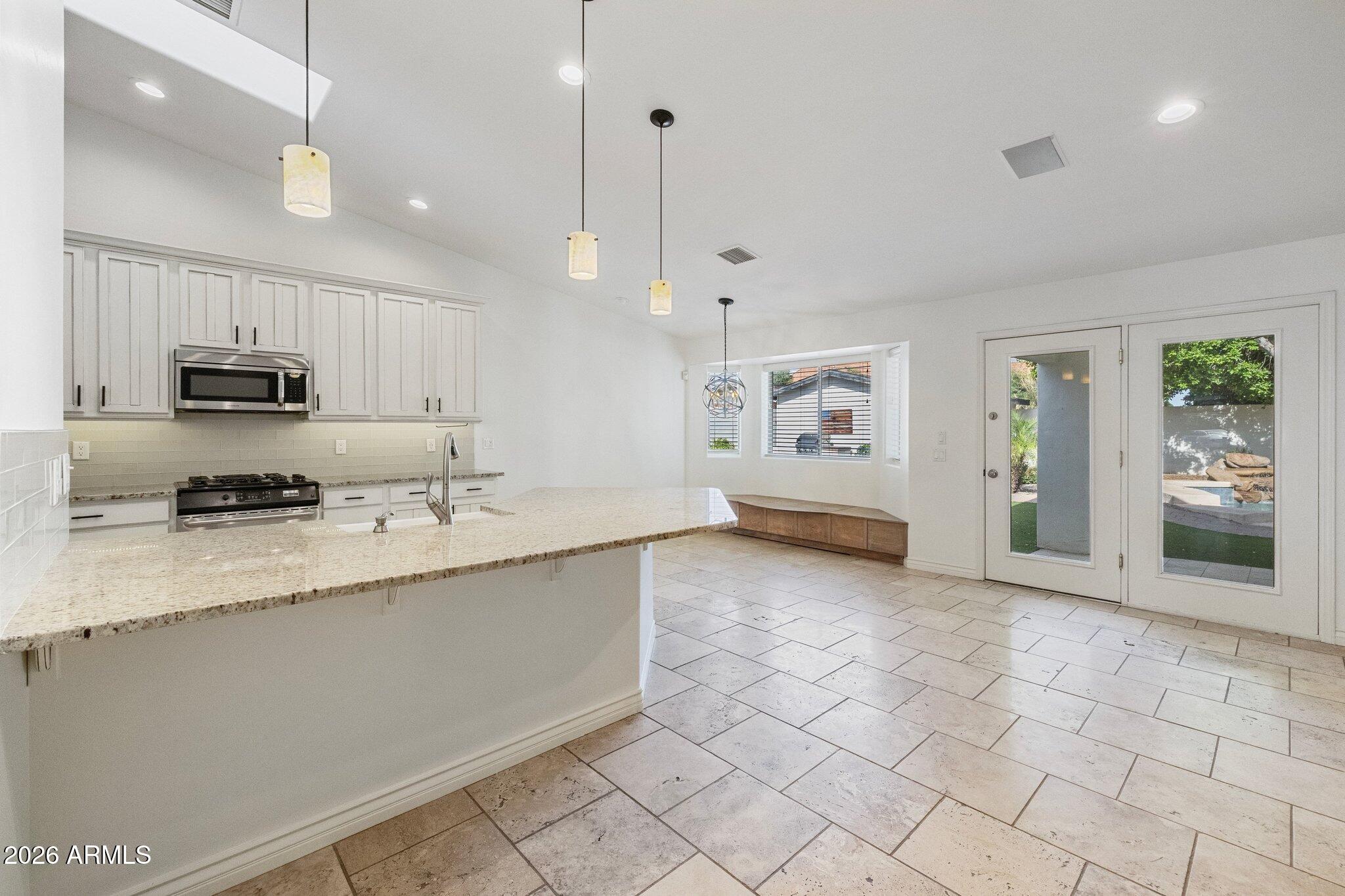 5233 North 15th Street Phoenix, AZ 85014 - Photo 5 of 26 a large white kitchen with a sink a counter top space appliances and cabinets