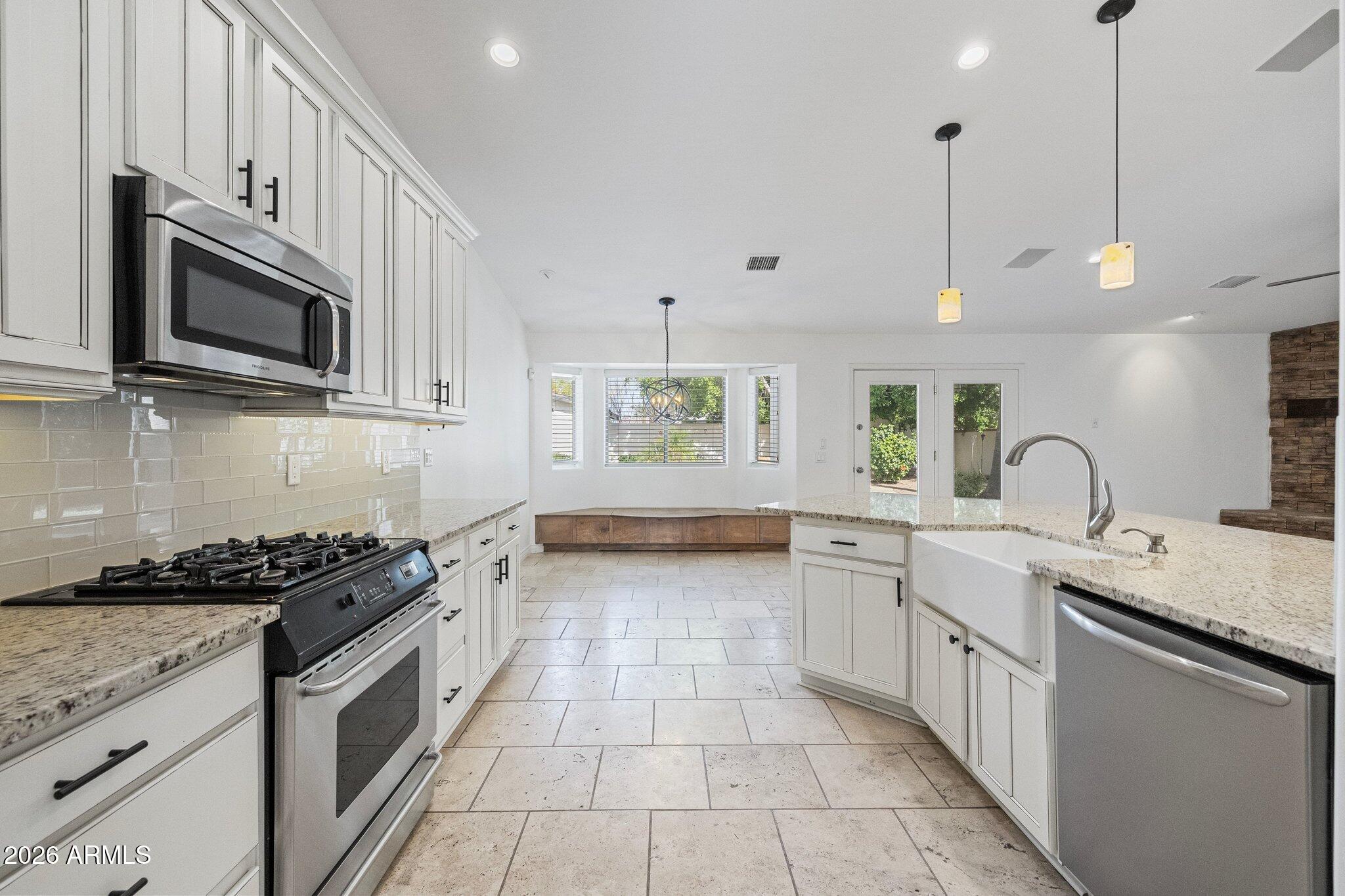 5233 North 15th Street Phoenix, AZ 85014 - Photo 6 of 26 a kitchen with stainless steel appliances granite countertop a stove a sink and a microwave