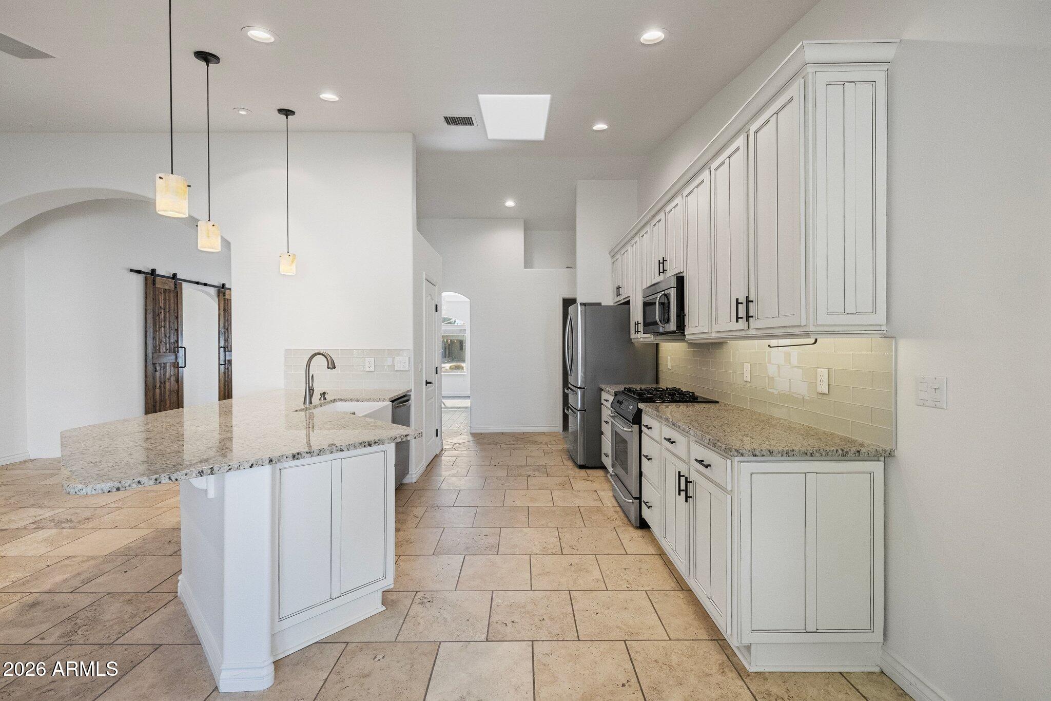 5233 North 15th Street Phoenix, AZ 85014 - Photo 8 of 26 a large kitchen with stainless steel appliances kitchen island granite countertop a sink and cabinets