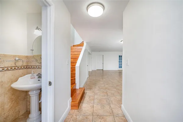 a view of a hallway with a kitchen space and a sink