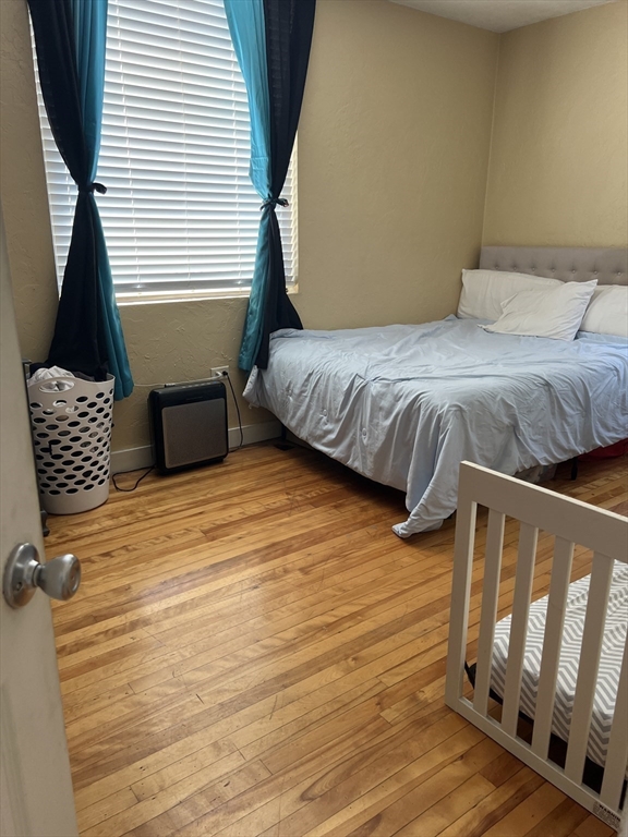17 Federal Street, Unit 606 Worcester, MA 01608 - Photo 13 of 24 a bedroom with a bed and wooden floor