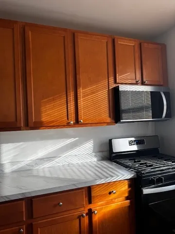 a kitchen with granite countertop wooden cabinets and stainless steel appliances