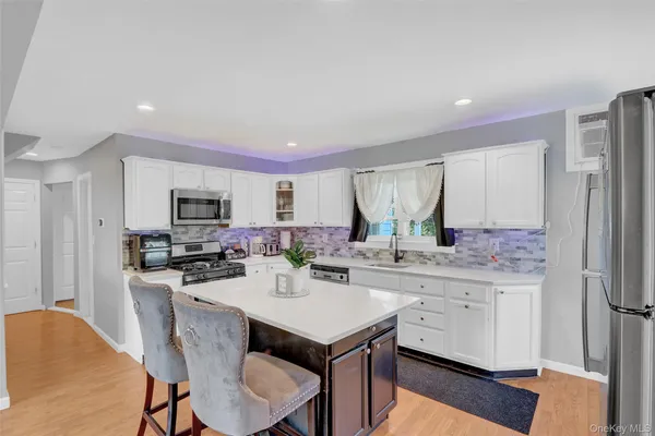 a kitchen with a sink a stove a refrigerator a white table and chairs
