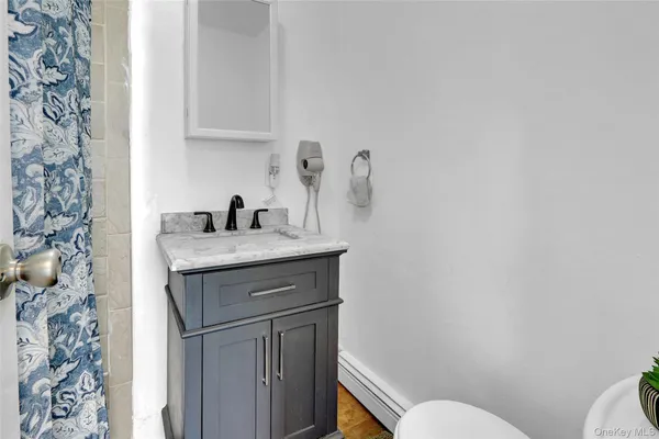 a bathroom with a granite countertop toilet sink and mirror