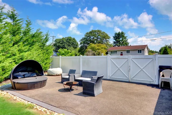 a roof deck with table and chairs and potted plants