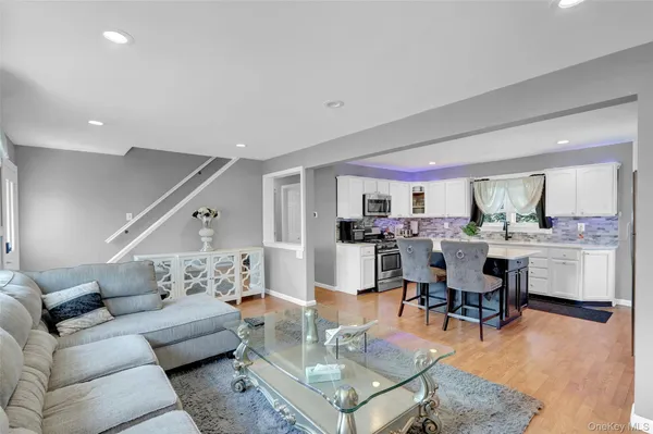 a living room with furniture and view of kitchen