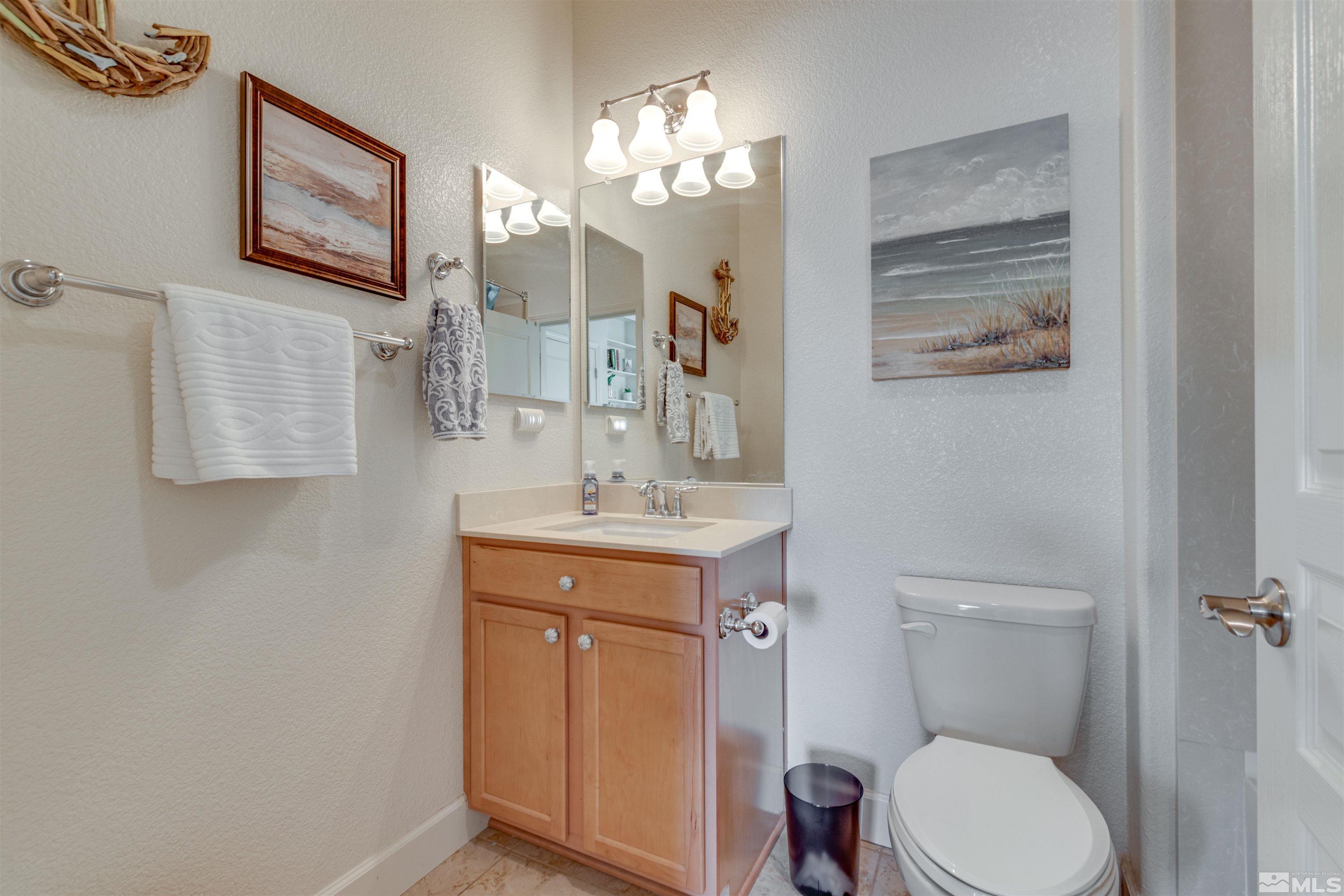 1180 Wakefield Trail Reno, NV 89523 - Photo 17 of 21 a bathroom with a toilet a sink and mirror