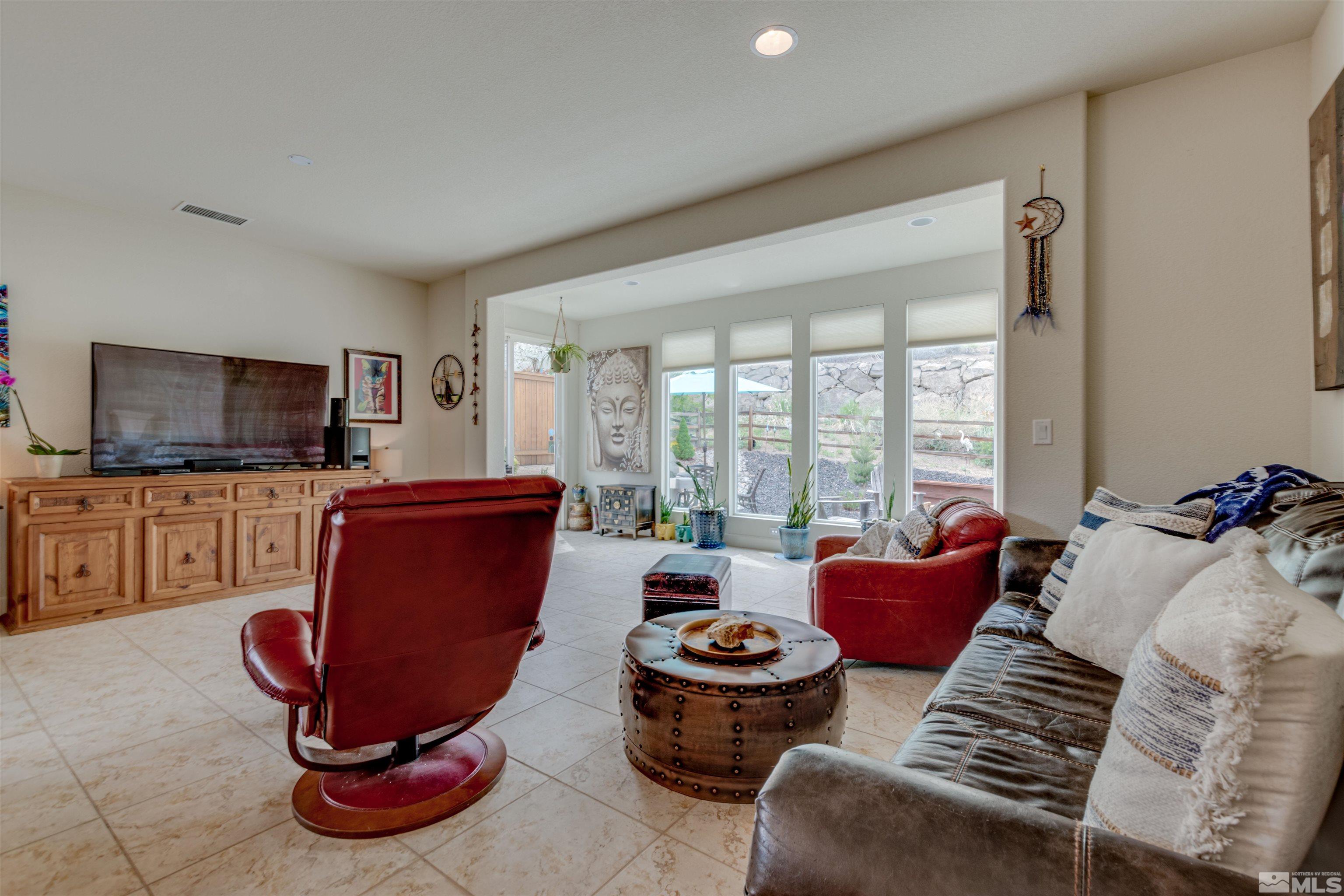 1180 Wakefield Trail Reno, NV 89523 - Photo 8 of 21 a living room with furniture a flat screen tv and a floor to ceiling window