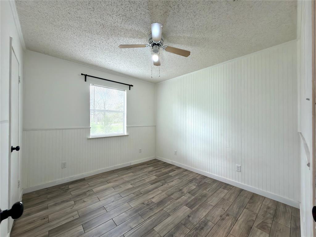 170 Granada Street Payne Springs, TX 75156 - Photo 11 of 20 wooden floor in an empty room with a window