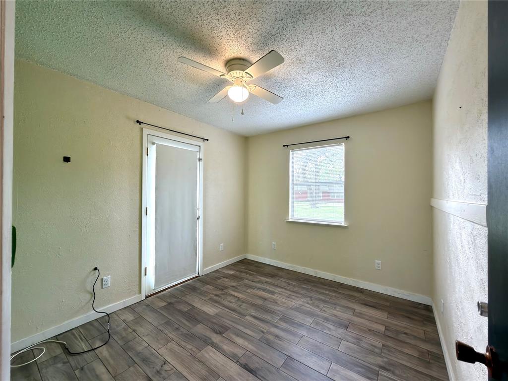 170 Granada Street Payne Springs, TX 75156 - Photo 12 of 20 a view of an empty room with wooden floor and a window