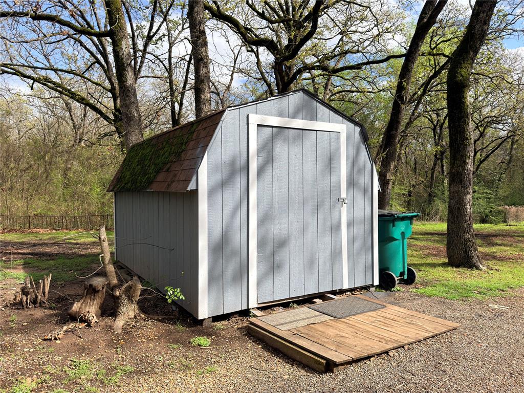170 Granada Street Payne Springs, TX 75156 - Photo 19 of 20 a backyard of a house with large trees and wooden fence