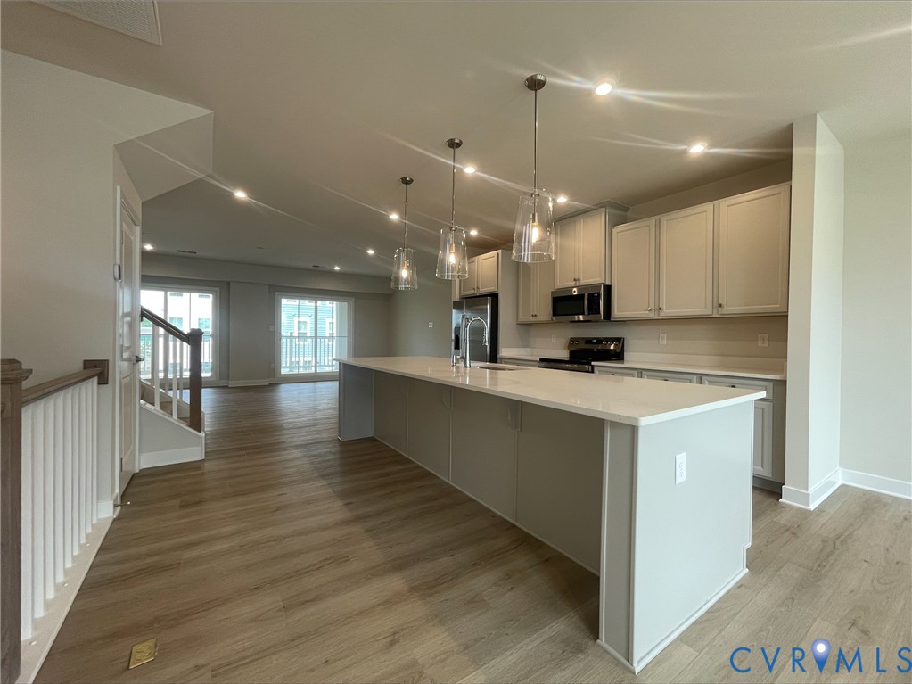 2860 Calgary Lane Chester, VA 23831 - Photo 3 of 16 a large white kitchen with lots of counter space wooden floor and stainless steel appliances