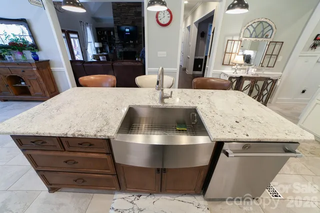 a view of kitchen island with stainless steel appliances wooden floor and living room view