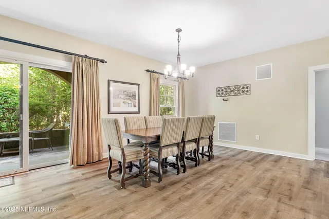 a kitchen with stainless steel appliances kitchen island granite countertop a table chairs and a refrigerator