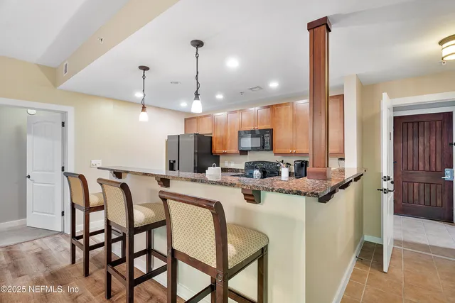 a kitchen with stainless steel appliances granite countertop a sink a stove and cabinets
