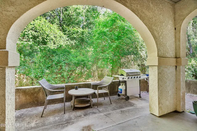 a view of a patio with table and chairs potted plants