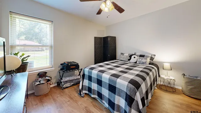 a bedroom with a bed and wooden floor