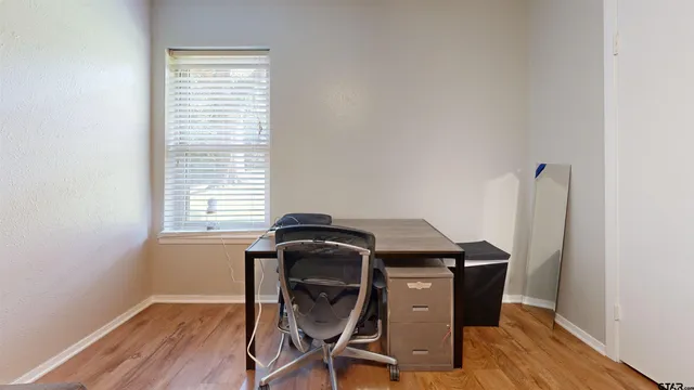 a view of a workspace with furniture and a window
