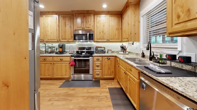 a kitchen with stainless steel appliances granite countertop a stove sink and cabinets