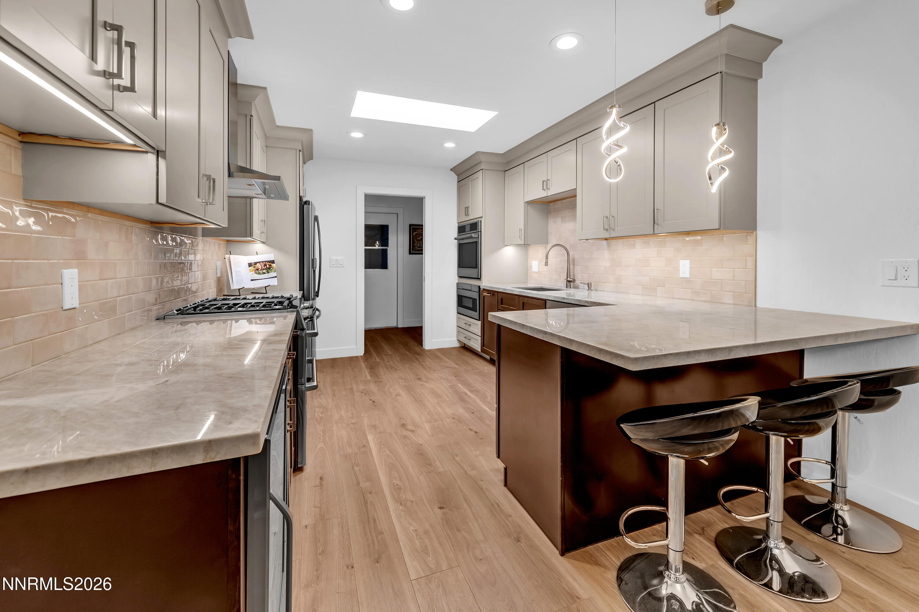 4915 Lakeridge Terrace West Reno, NV 89509 - Photo 17 of 41 a kitchen with stainless steel appliances kitchen island granite countertop a table chairs in it and wooden floors