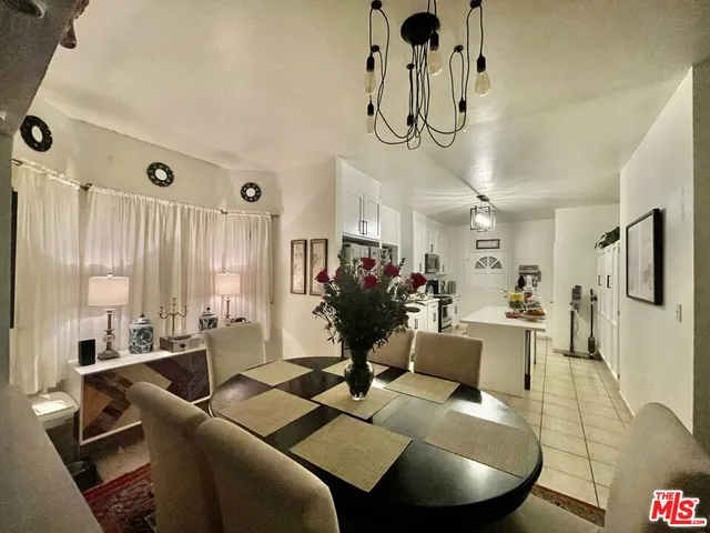 a living room with furniture a dining table and a chandelier
