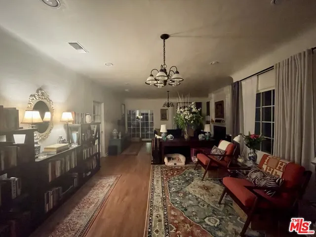 a living room with furniture a dining table and a chandelier