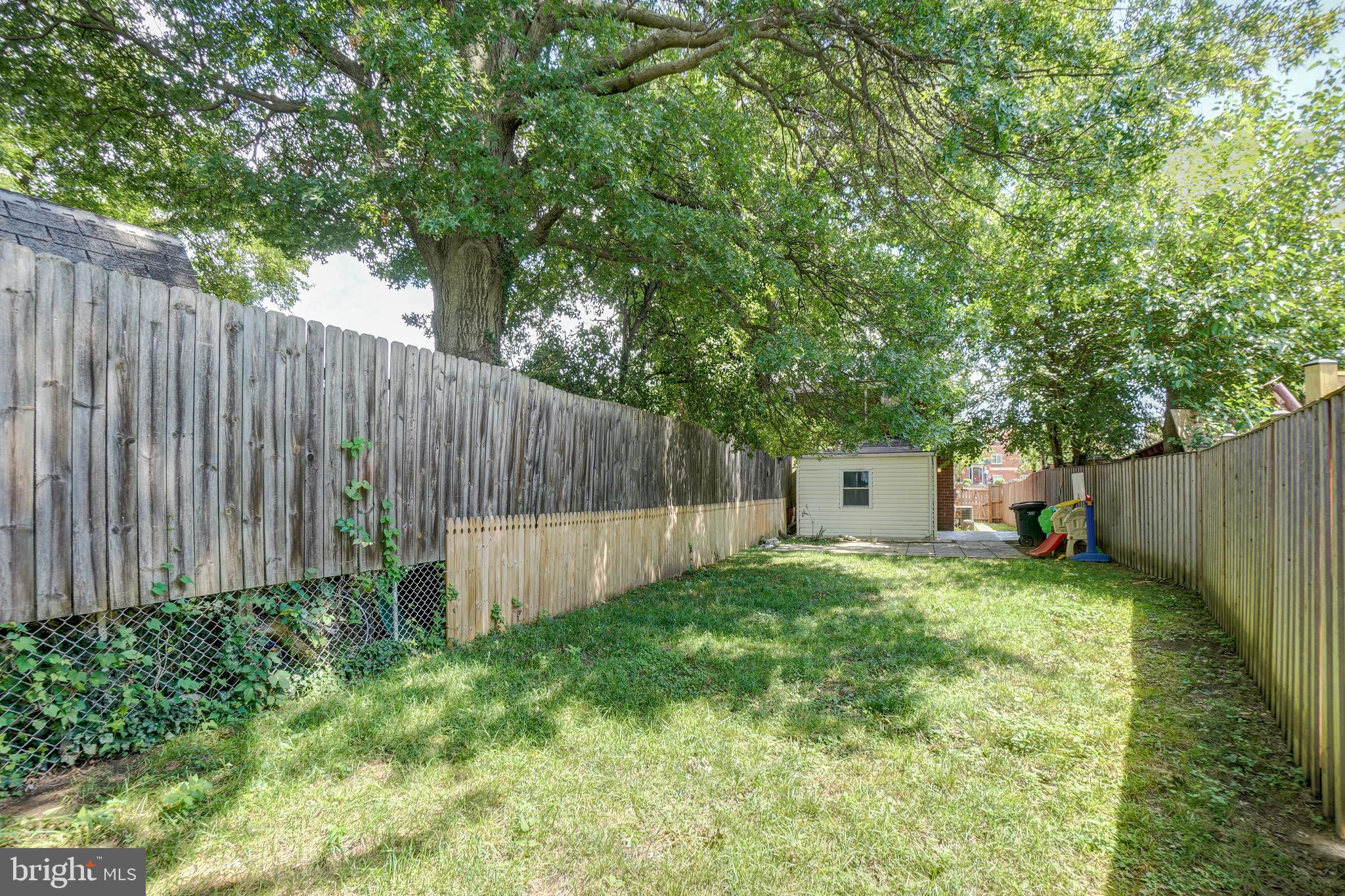628 Four Mile Road Alexandria, VA 22305 - Photo 24 of 29 a view of a backyard with large trees and wooden fence