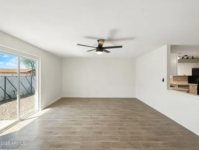 a view of a livingroom with wooden floor and a ceiling fan