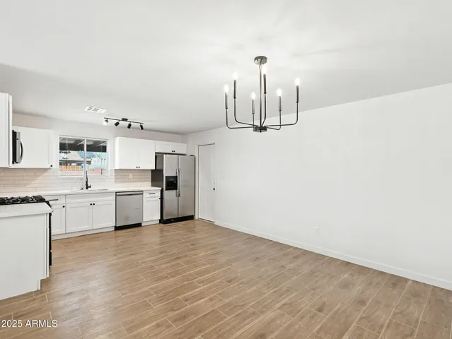a kitchen with cabinets a sink and white stainless steel appliances