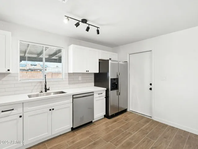a kitchen with a sink cabinets and stainless steel appliances