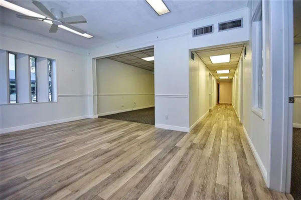 a view of a room with wooden floor and a hallway