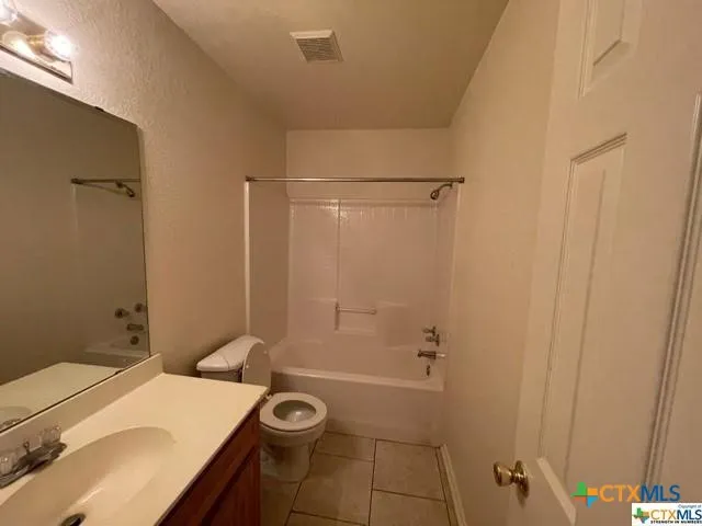 a bathroom with a granite countertop sink a toilet and shower