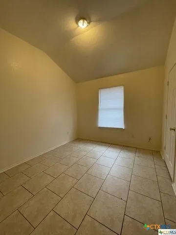 an empty room with a ceiling fan and carpet