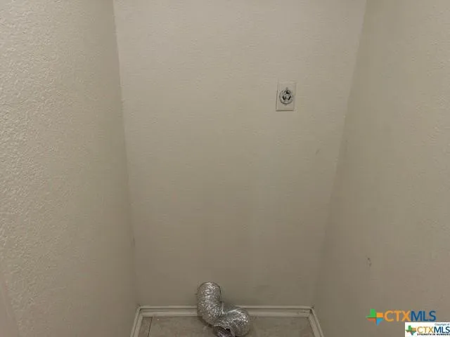 an empty room with chandelier fan