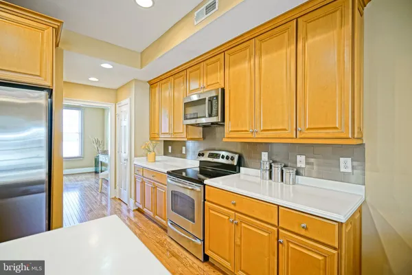 a kitchen with stainless steel appliances granite countertop a sink a stove and a refrigerator