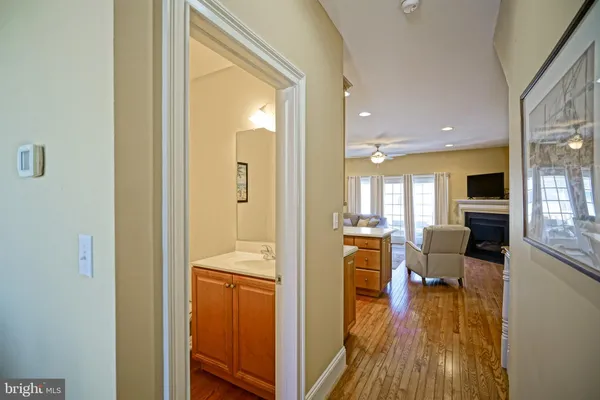 a view of a living room and a wooden floor in a hall with an entryway
