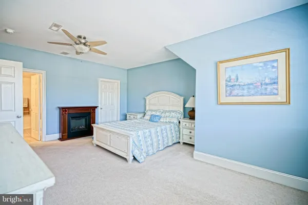 a spacious bedroom with a bed and a fireplace