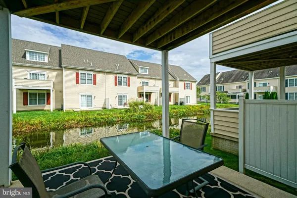 a view of a patio with table and chairs and potted plants with wooden floor