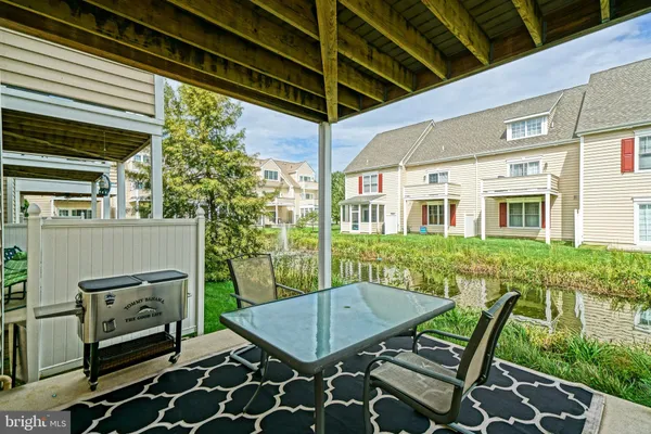 a view of deck with table and chairs and potted plants