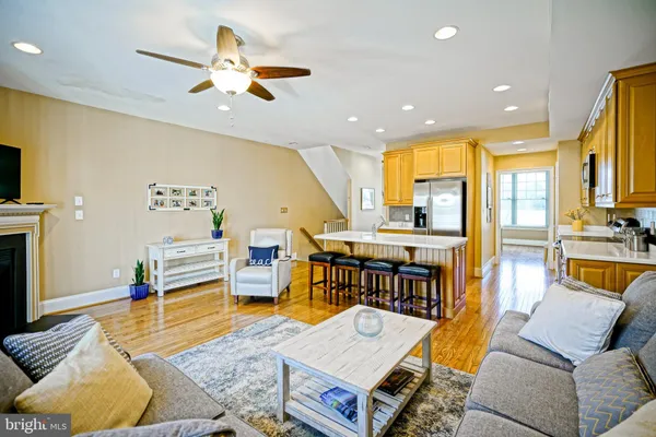 a living room with furniture kitchen view and a large window