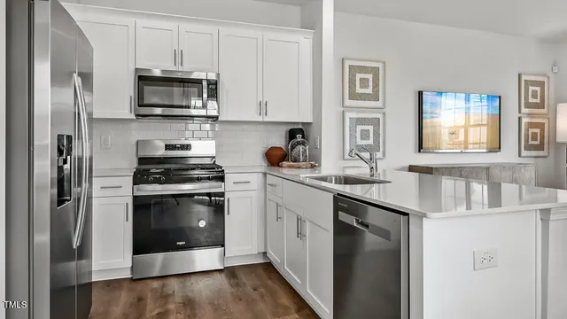 a kitchen with stainless steel appliances a stove a sink and a refrigerator