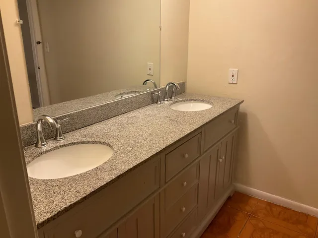 a bathroom with a granite countertop sink and a mirror