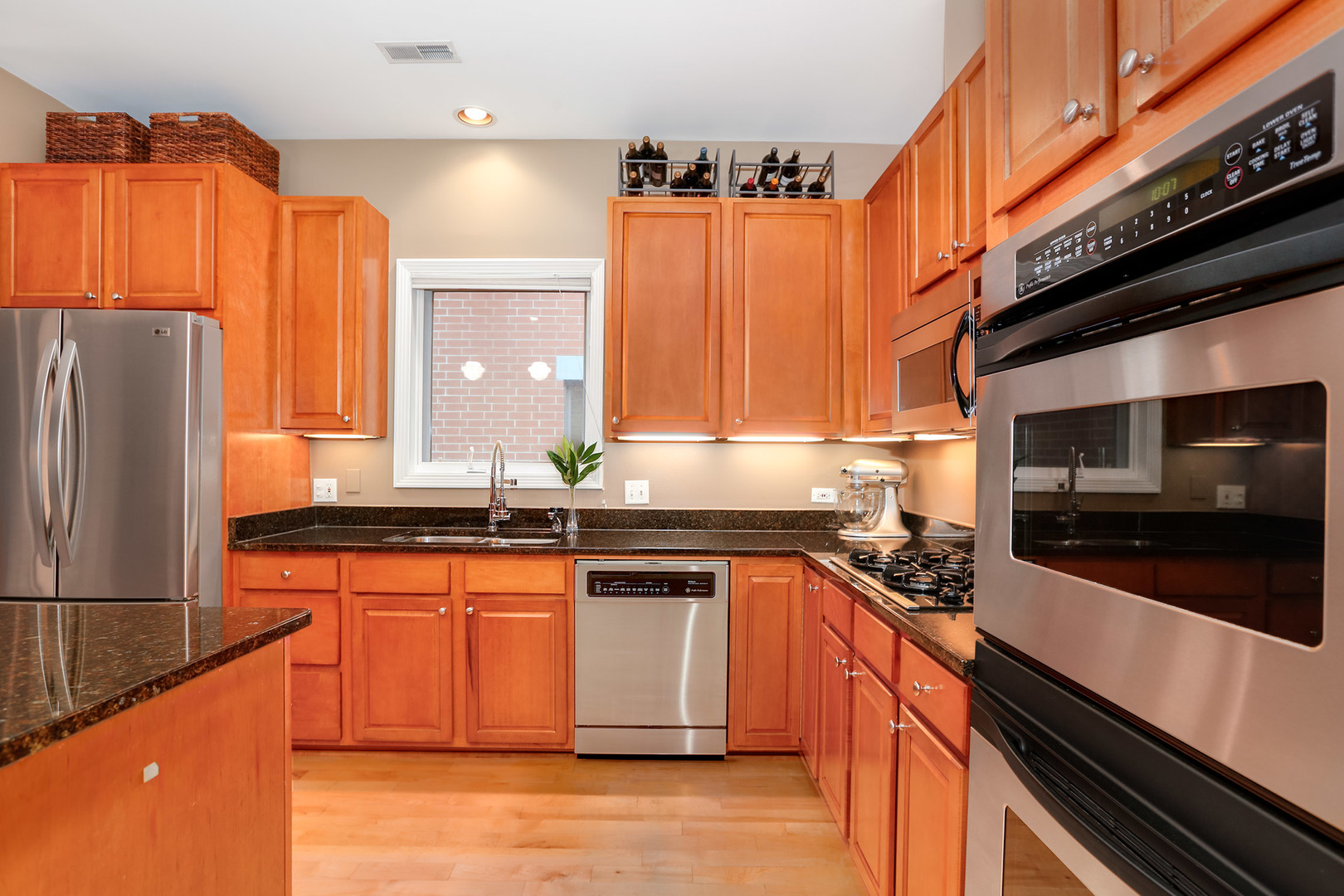 321 North Jefferson Street, Unit 401 Chicago, IL 60661 - Photo 8 of 33 a kitchen with stainless steel appliances wooden cabinets and a stove top oven