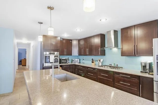 a large kitchen with kitchen island a large counter space a sink and stainless steel appliances