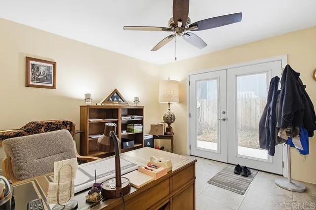 a view of a workspace with furniture and a ceiling fan