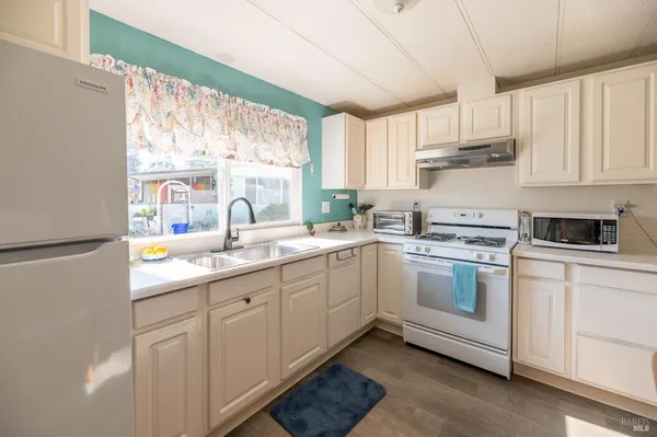 a kitchen with white cabinets and white appliances