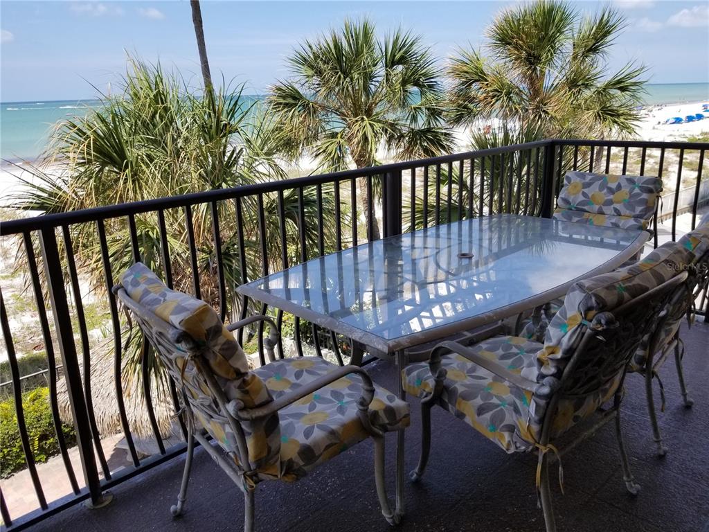 13650 Gulf Boulevard, Unit 304 Madeira Beach, FL 33708 - Photo 6 of 63 a view of a chairs and table in patio with wooden fence