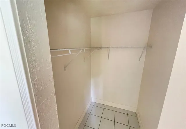 a view of an empty room and chandelier fan