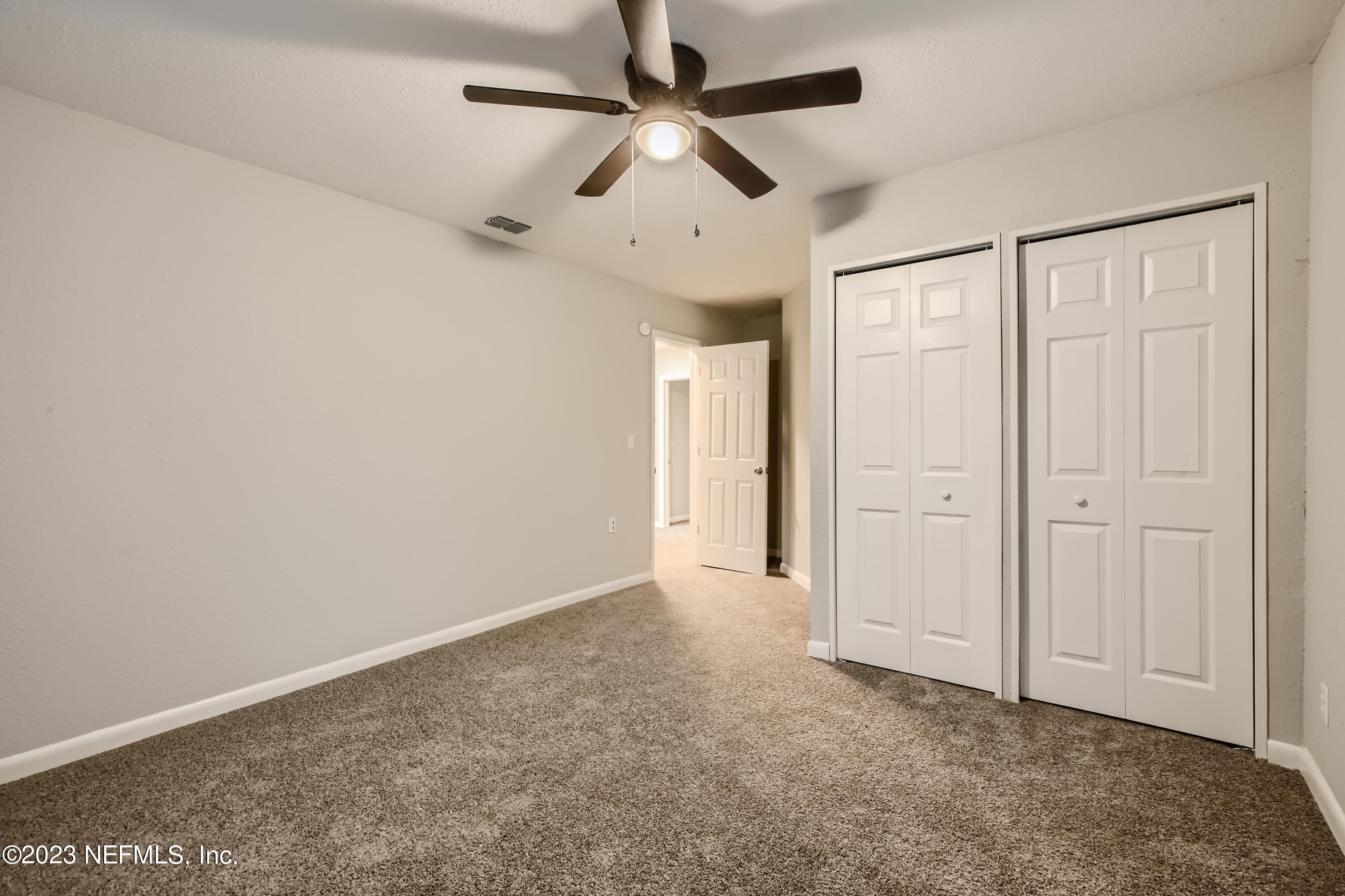 5730 Moncrief Road Jacksonville, FL 32209 - Photo 23 of 37 an empty room with a ceiling fan and carpet