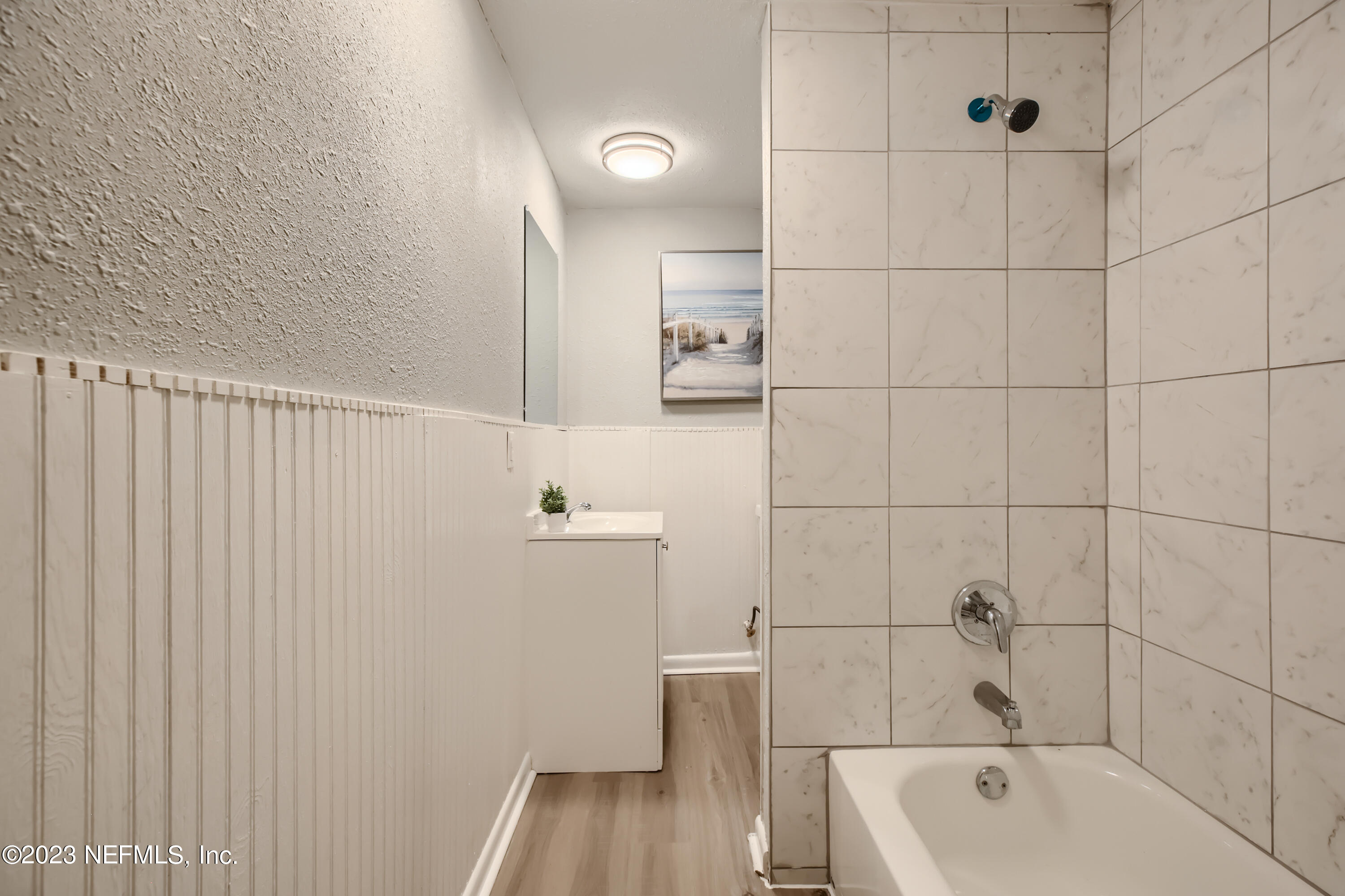 5730 Moncrief Road Jacksonville, FL 32209 - Photo 26 of 37 a bathroom with a bathtub a toilet a sink and wooden floor